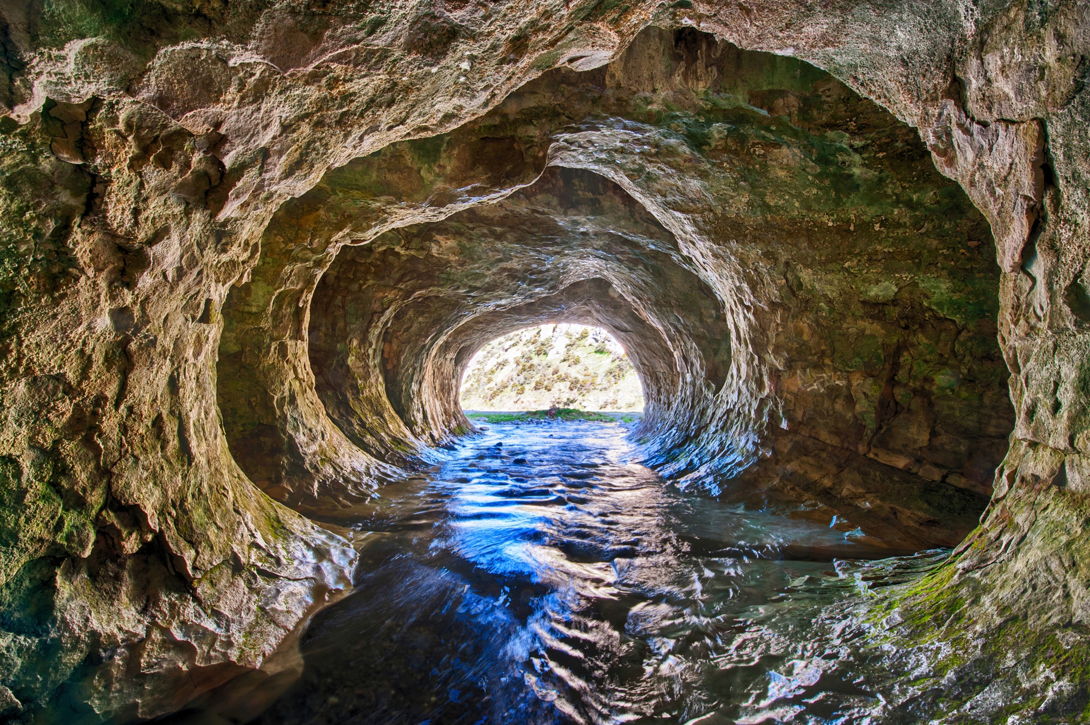 Papermoon Fototapete »GROTTE-NEUSEELAND HÖHLE STROM BERGE MEER FLUSS FELSEN günstig online kaufen