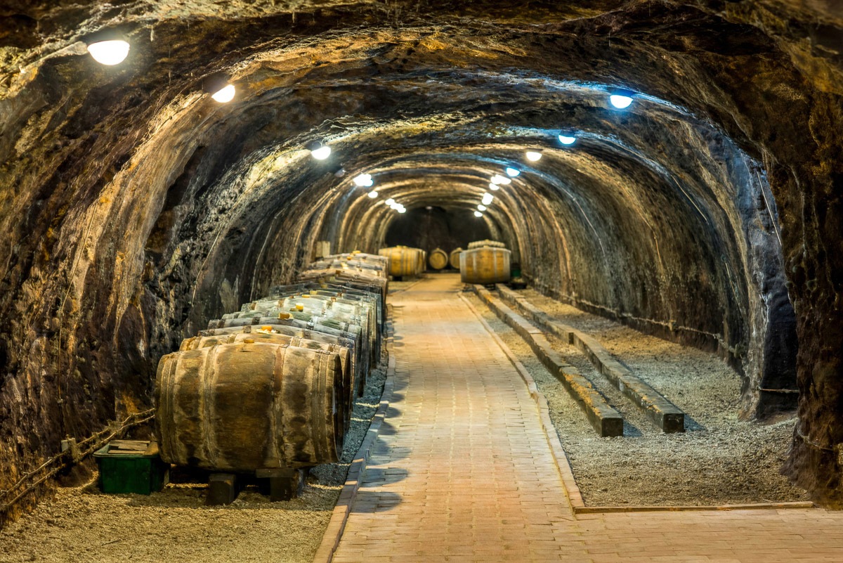 Papermoon Fototapete »Tunnel mit Fässern«